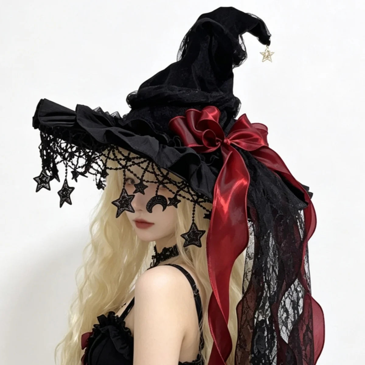 Black lace witch hat with red bow on model, star and moon fringe, side view