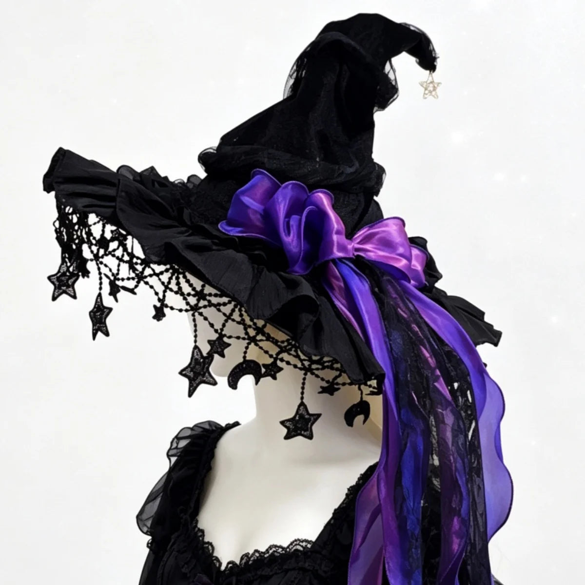 Black lace witch hat with purple bow on mannequin, side view