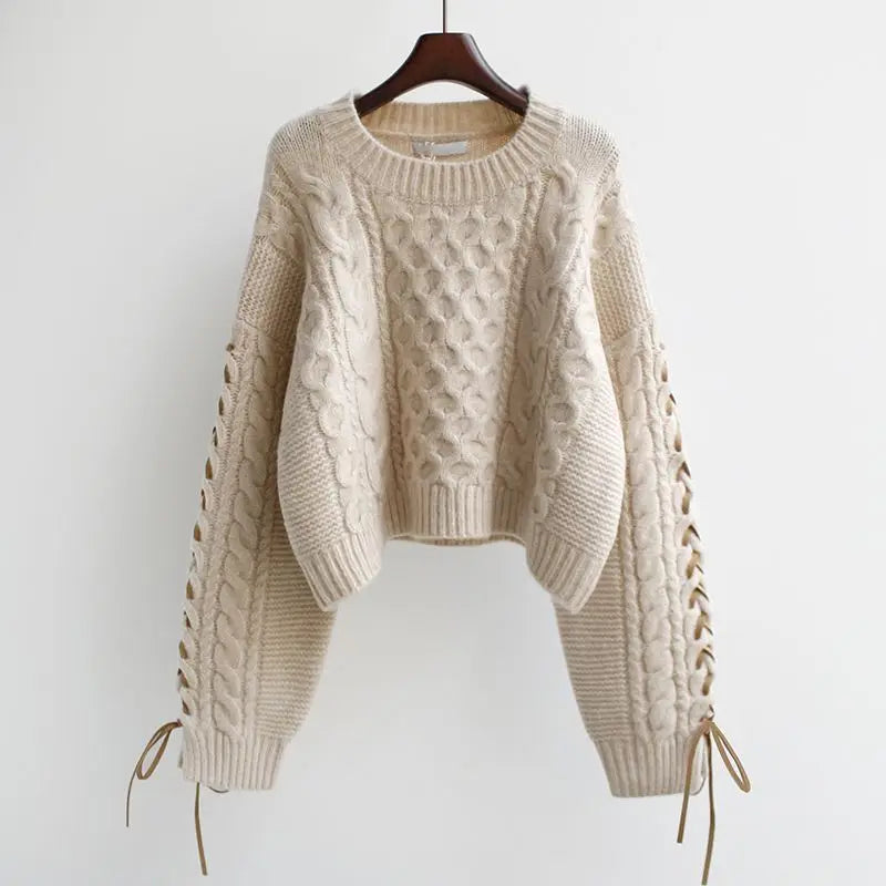 Beige cable knit sweater with white shirt and pleated skirt, layered preppy look