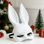 White glossy bunny ear mask on table with Christmas tree and gifts