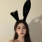 Model wearing shiny black rabbit ear headband, front view