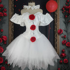 White creepy clown corset costume with red pom poms on mannequin among red roses