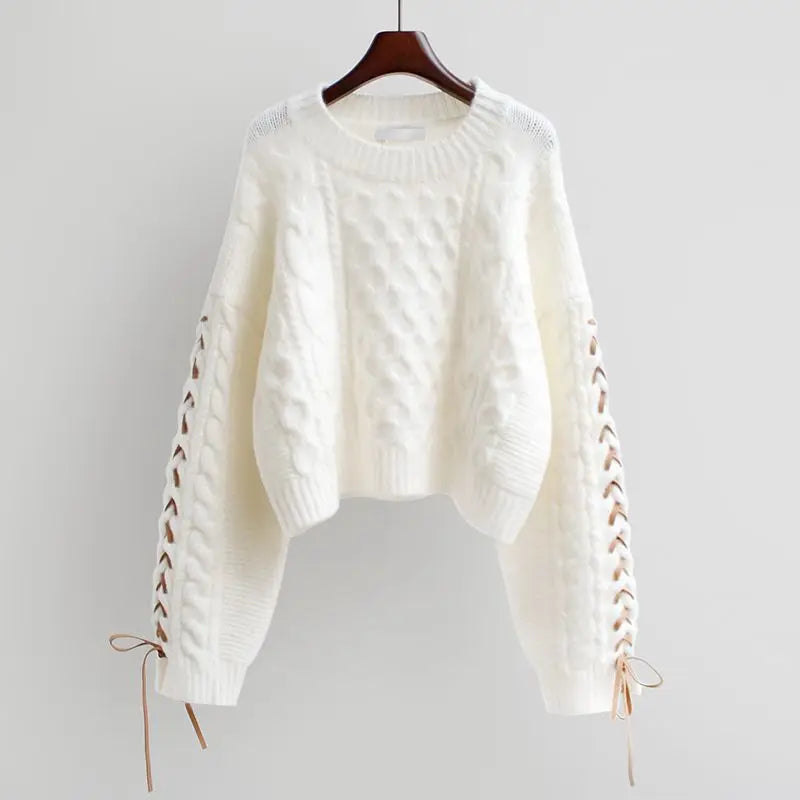 Beige cable knit sweater with white shirt and pleated skirt, chunky cable knit texture