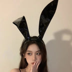 Model wearing shiny black rabbit ear headband with flopped ear, front view