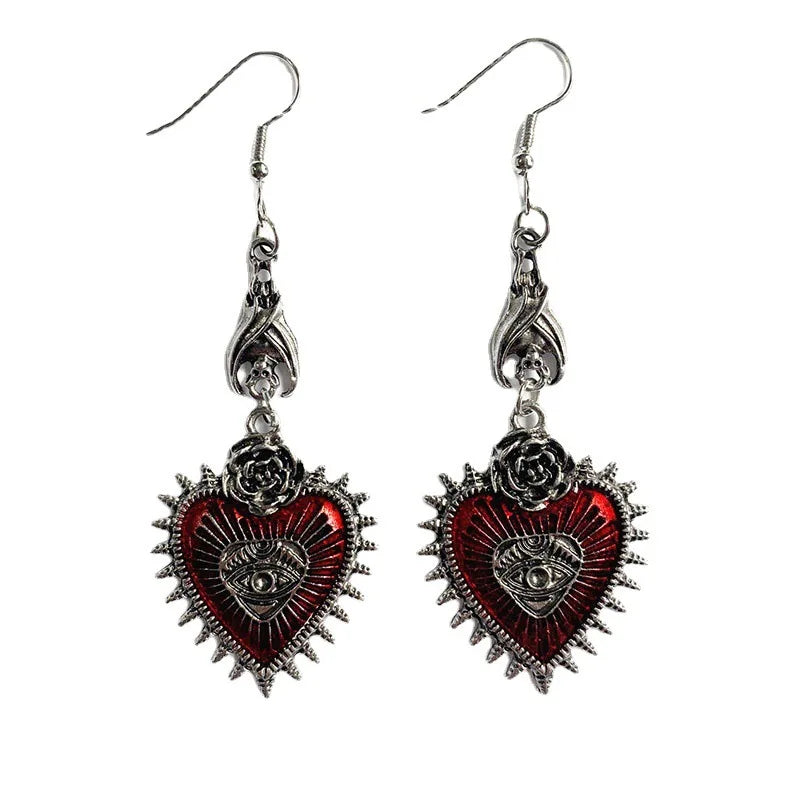 Red enamel heart evil eye dangle earrings with spiked border, front view