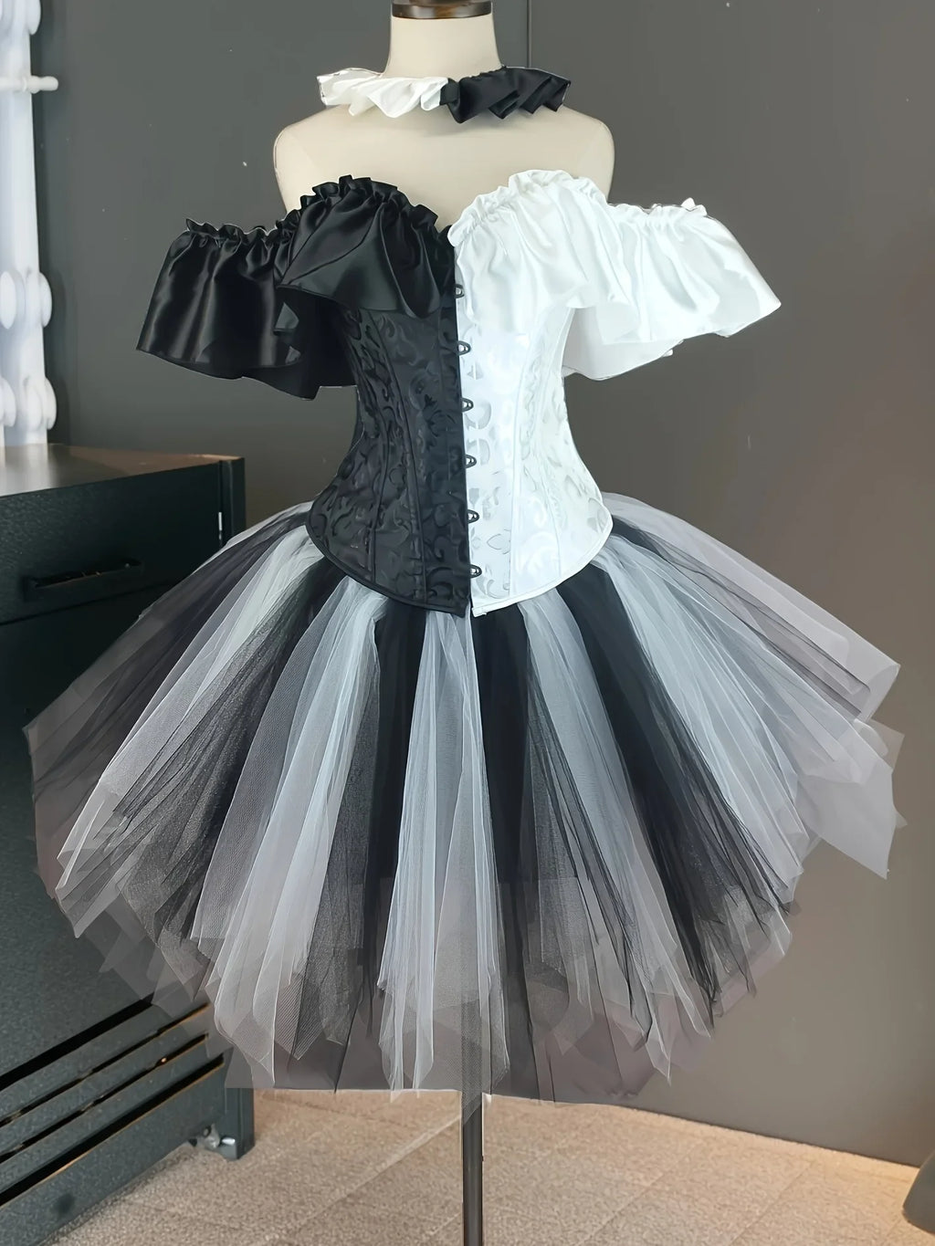 Black and white split creepy clown corset costume on mannequin, front view