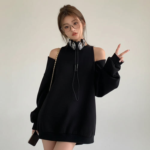 Black loose fit women's sweatshirt with cold shoulder design worn by model with glasses and headphones