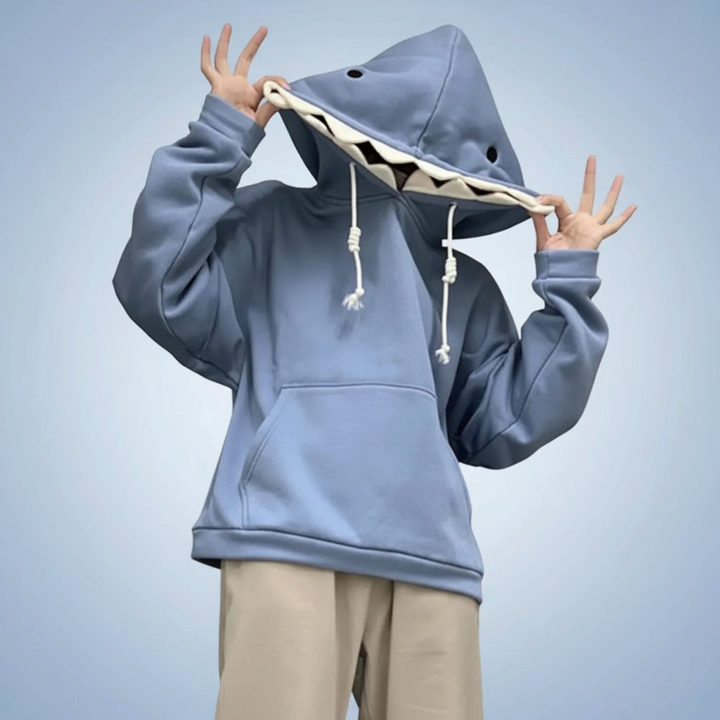 Blue oversized shark pullover hoodie with shark teeth design on the hood worn with beige pants