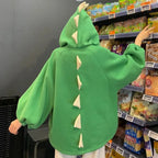 Green cartoon dinosaur japanese hoodie for women with back spikes and loose sleeves in a store