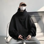 Black casual Japanese streetwear fashion hoodie with oversized fit and high collar worn by a seated person