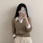 Woman wearing beige casual knitwear for women layered over white collared shirt taking a mirror selfie