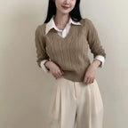 Woman wearing beige cable knit sweater layered over white collared shirt casual knitwear for women