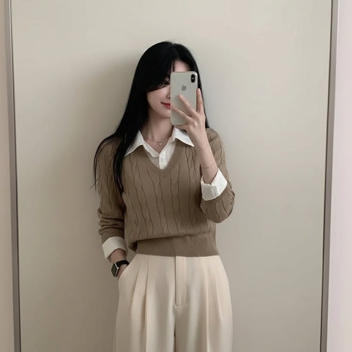 Woman wearing beige casual knitwear for women with a white collared shirt and cream skirt taking a mirror selfie