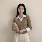 Woman wearing brown casual knitwear for women layered over a white collared shirt holding a book