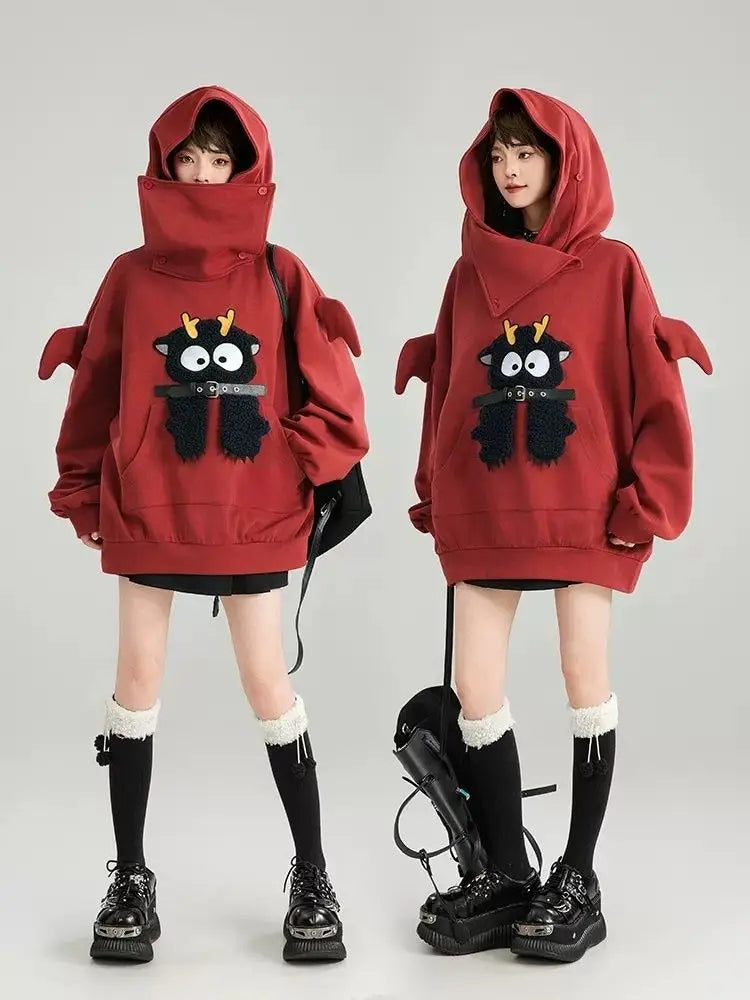 Cute oversized kawaii hoodie for girls in red with playful cartoon character and dragon wing sleeves