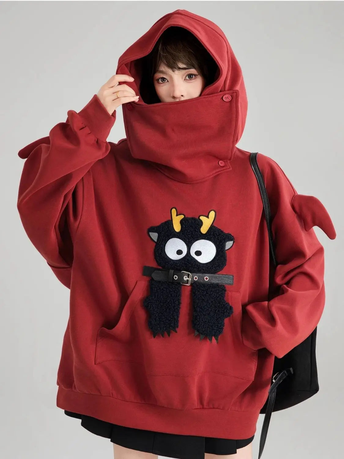 Cute oversized kawaii hoodie for girls in red with a playful black character and yellow horns design