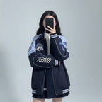 Embroidered baseball cap style jacket with checkerboard and cartoon patches in black and blue