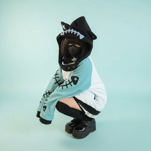 Person wearing black and teal harajuku shark grunge zip up sweatshirt with hood and face mask outdoor