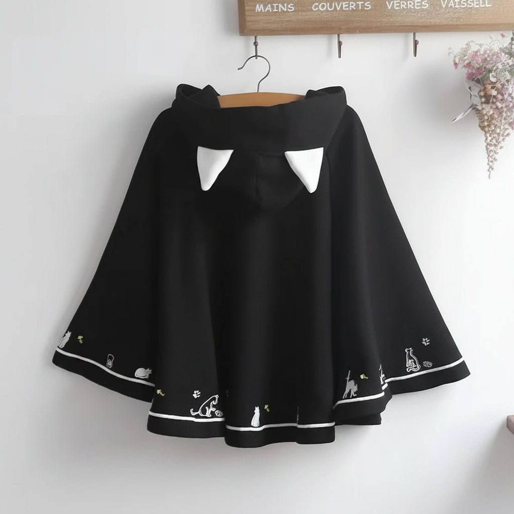 Black Harajuku style cape for women with white cat ear details and cute animal designs on the hem