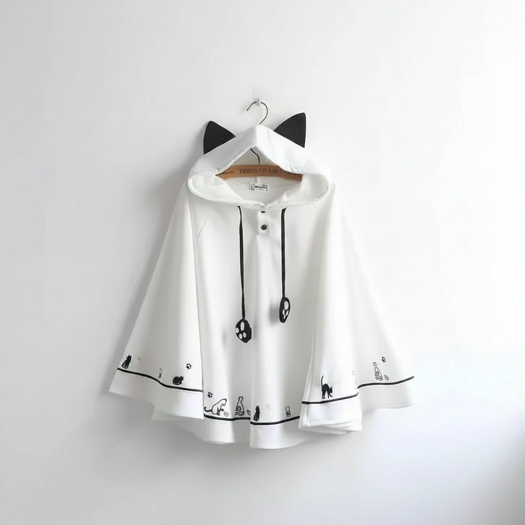 White Harajuku style cape for women with black cat ears hood and playful cat paw and silhouette designs