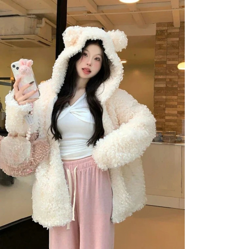 Woman wearing a cozy japanese style lamb wool coat with bear ears hood and holding a fluffy purse