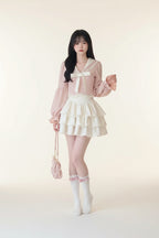 Woman wearing pink bowknot two piece skirt set with long puff sleeves and tiered white skirt