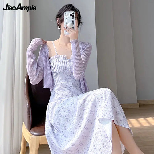 Woman wearing purple floral two piece dress with a matching light purple cardigan sitting on a wooden chair