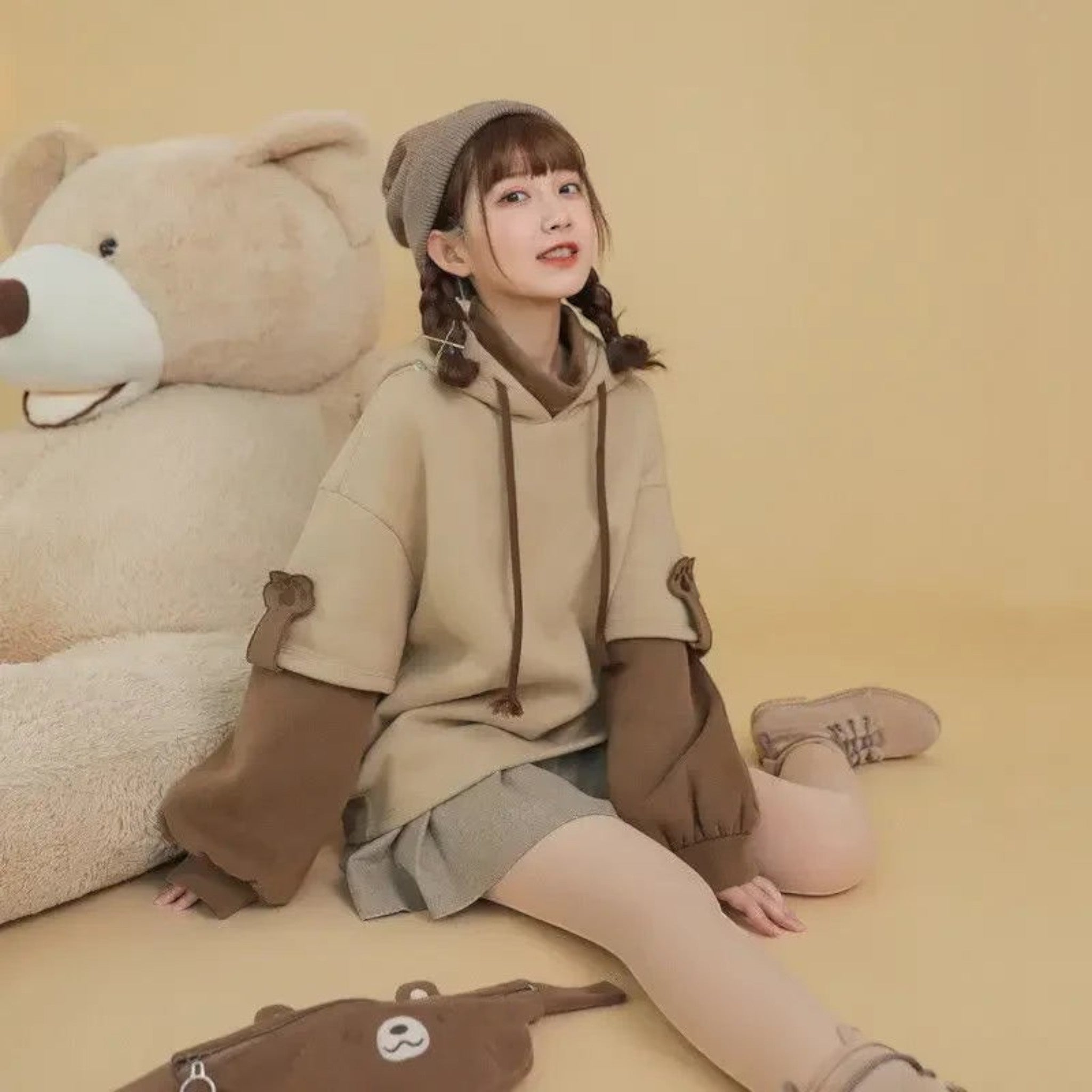 Kawaii bear anime Crewneck Long Sleeve hoodie in beige and brown worn by a seated girl with braided hair and beanie