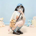 Kawaii cartoon long sleeve t shirt with bear and polka dot design worn by person with blue cap and striped socks