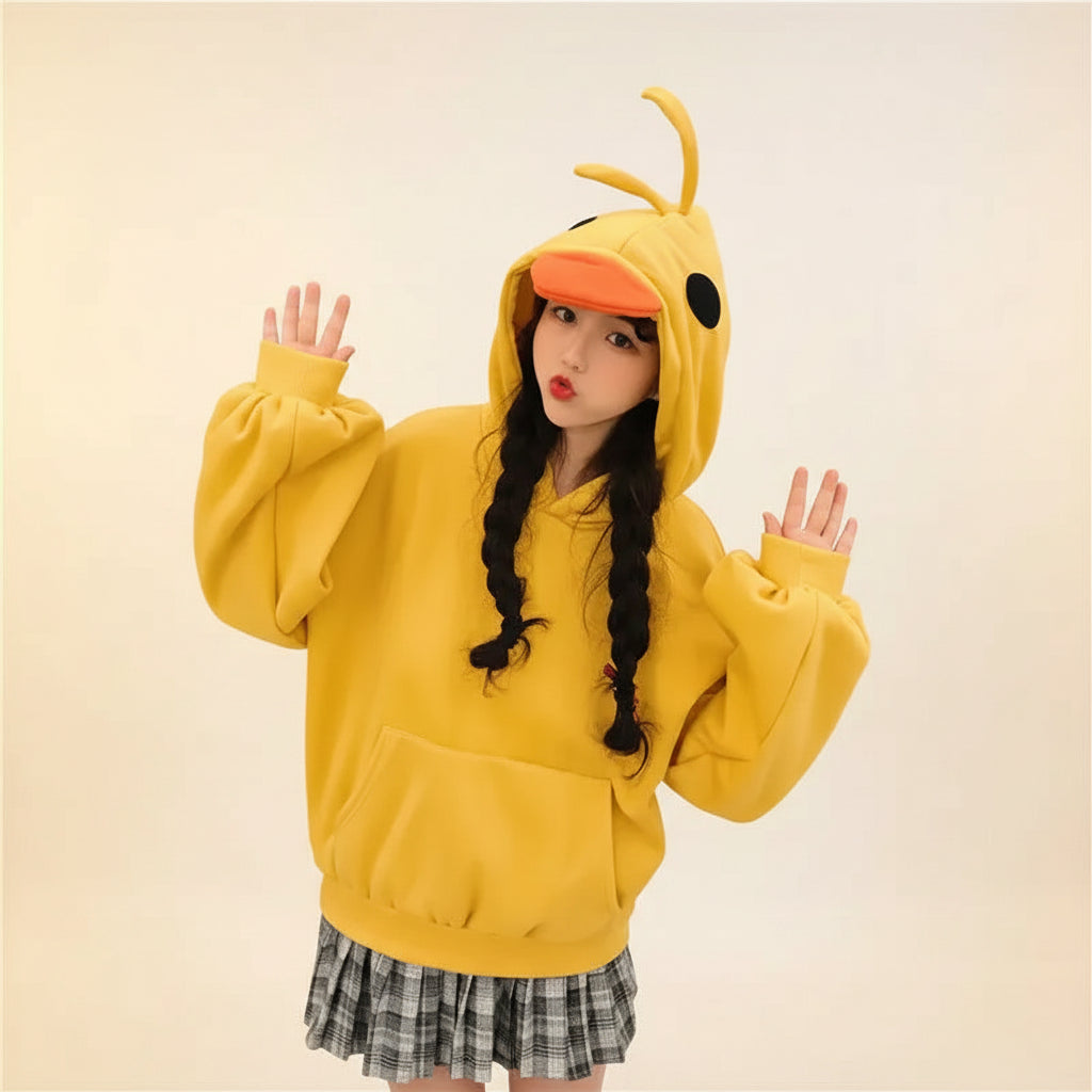 Woman wearing a yellow kawaii duck hoodie for women with 3D beak and eye details in a casual indoor setting