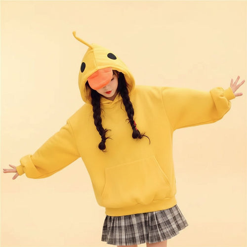 Woman wearing a yellow kawaii duck hoodie for women with duck face and beak hood in casual indoor setting