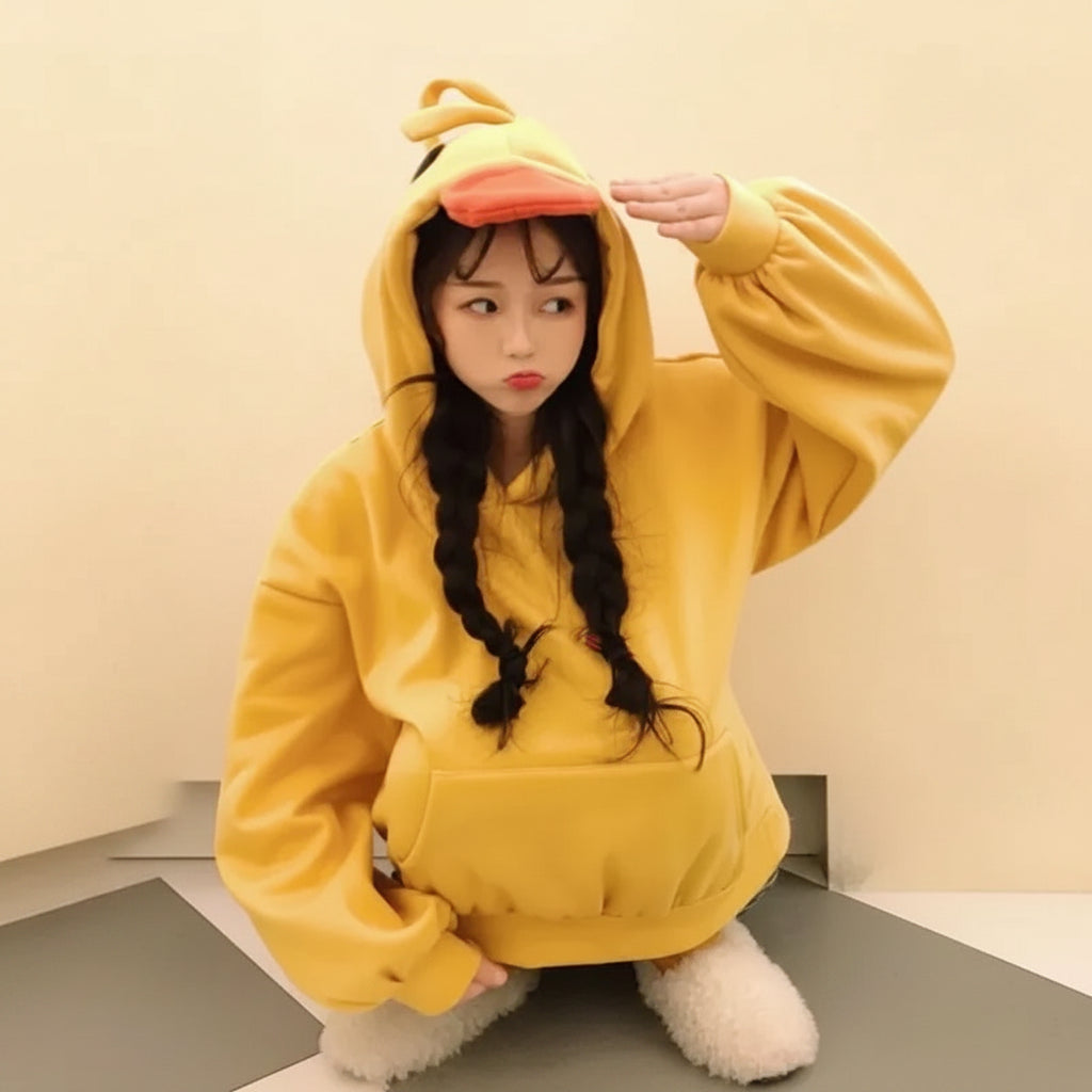 Young woman wearing a kawaii duck hoodie for women in bright yellow with a duck beak hood and oversized fit