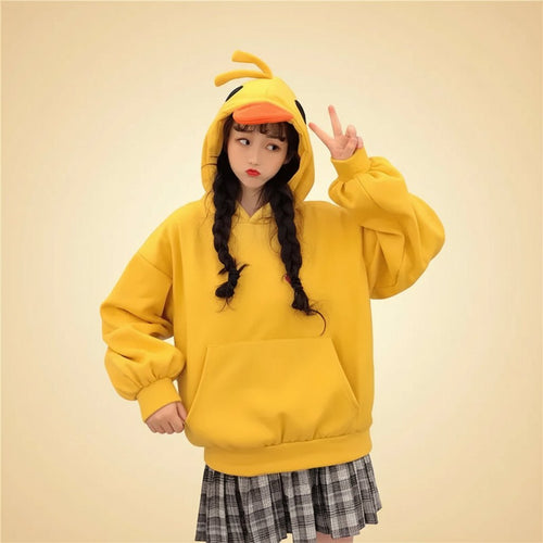 Woman wearing a bright yellow kawaii duck hoodie for women with duck bill and head details posing indoors