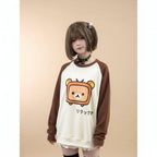 Japanese kawaii pullover top with brown sleeves and a cute bear graphic worn by a model inside