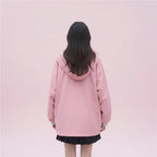 Woman wearing pink kawaii japanese style spring outerwear with hood and oversized fit walking outdoors