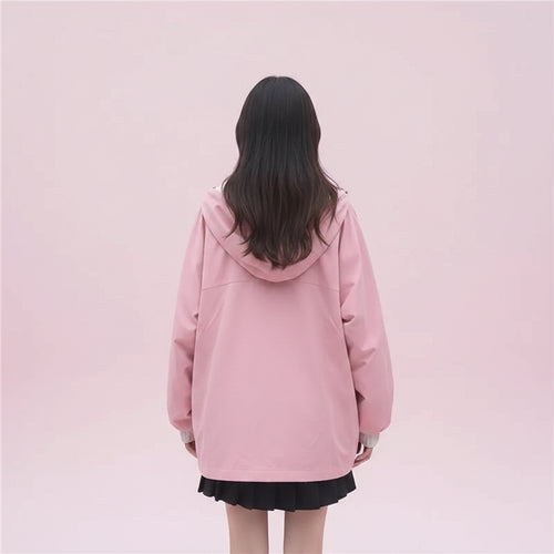 Woman wearing pink kawaii japanese style spring outerwear with hood and oversized fit walking outdoors