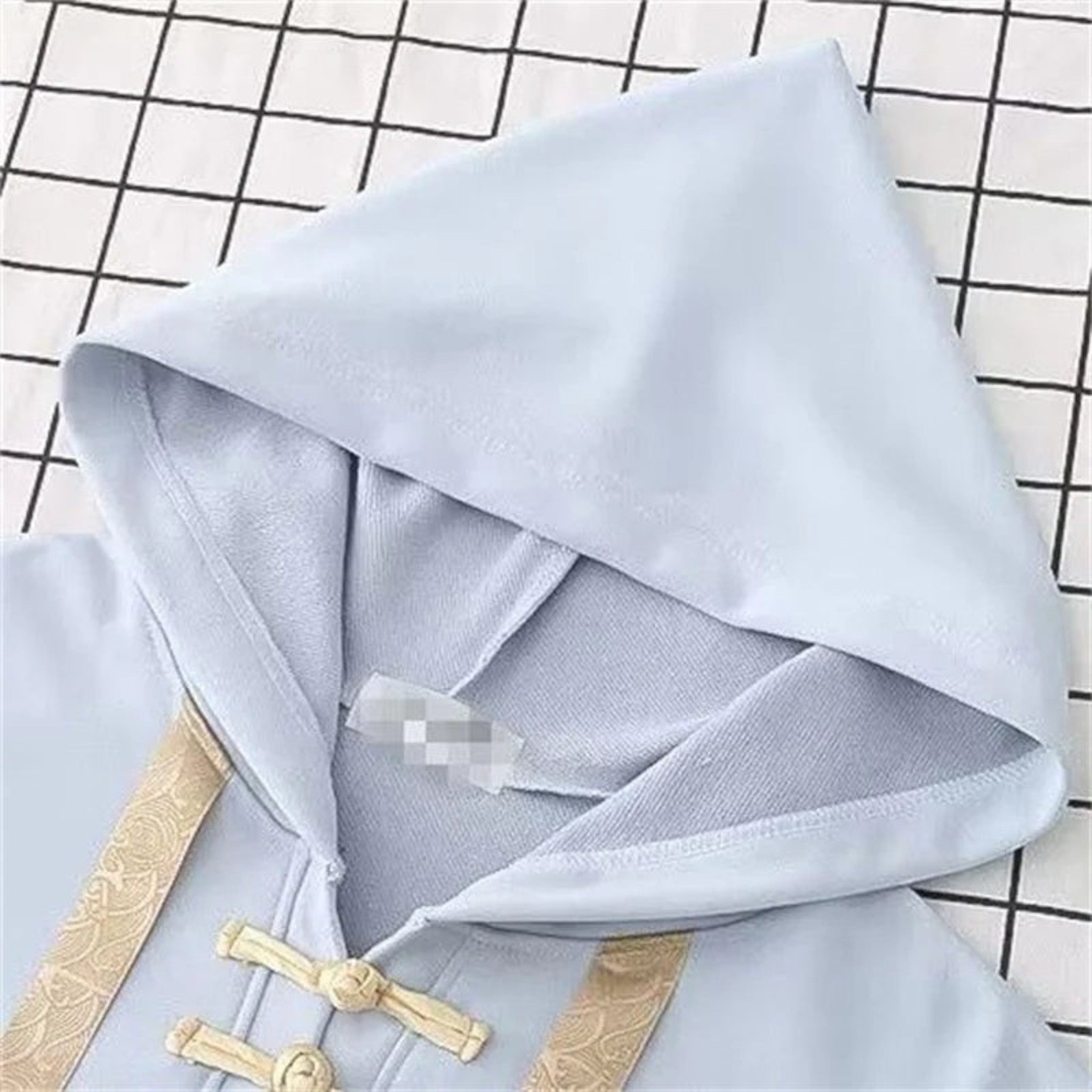 Light blue kawaii loose long sleeve spring hoodie with beige decorative buttons on grid background