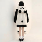 Back view of kawaii panda hooded cute jacket with black sleeves worn by a child standing indoors