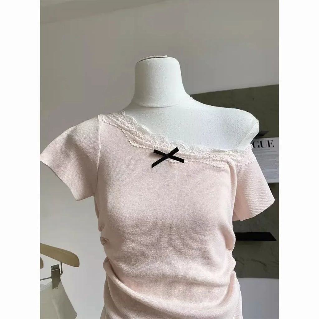 Kawaii pink bowknot top and skirt set featuring a soft pink off-shoulder top with lace and black bow detail