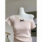 Kawaii pink bowknot top and skirt set featuring a soft pink off-shoulder top with lace and black bow detail