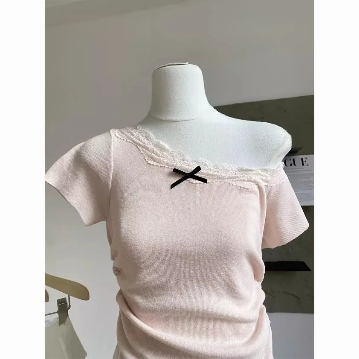 Kawaii pink bowknot top and skirt set featuring a soft pink off-shoulder top with lace and black bow detail