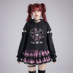 Black kawaii preppy patchwork crop hoodie with cut-out sleeves and pink graphic design paired with pink plaid skirt
