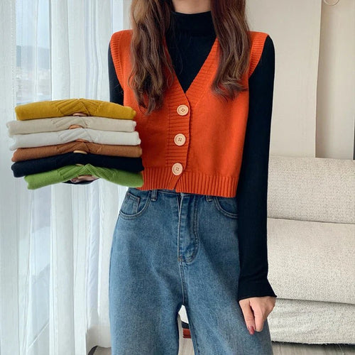 Korean fashion crop knit top in various colors held by a model styled with denim jeans