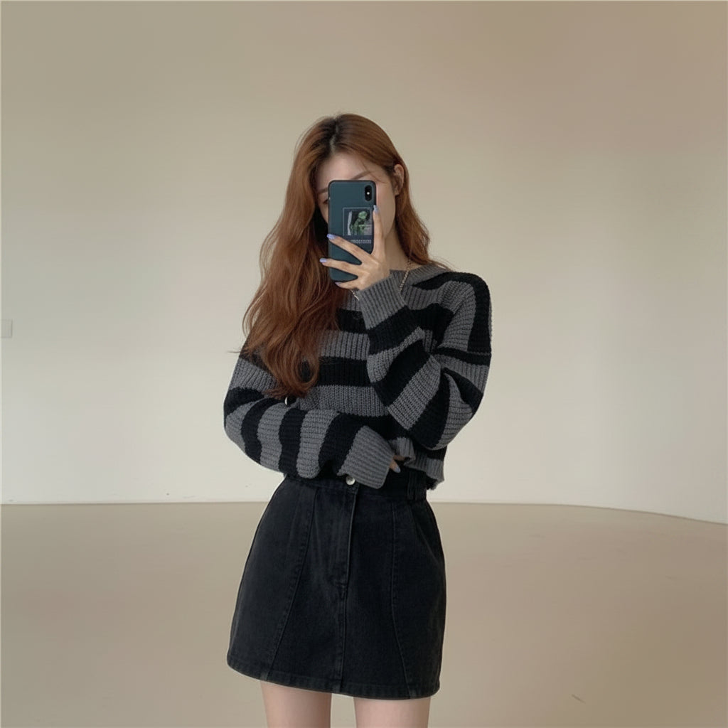 Woman wearing a Korean striped knit sweater in black and gray posing indoors with a modern minimalist background