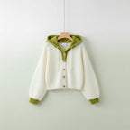 Korean style cardigan sweater with white body green hood and cuffs hanging on a hanger