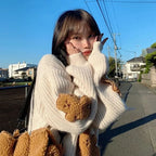 Woman wearing a Korean style loose bear jumper with teddy bear patches on sleeves outdoors