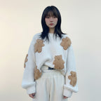 Woman wearing a white Korean style loose bear jumper with brown plush bear patches outdoors