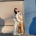 Woman wearing Korean style loose bear jumper with teddy bear patches standing outdoors holding a bear-shaped bag