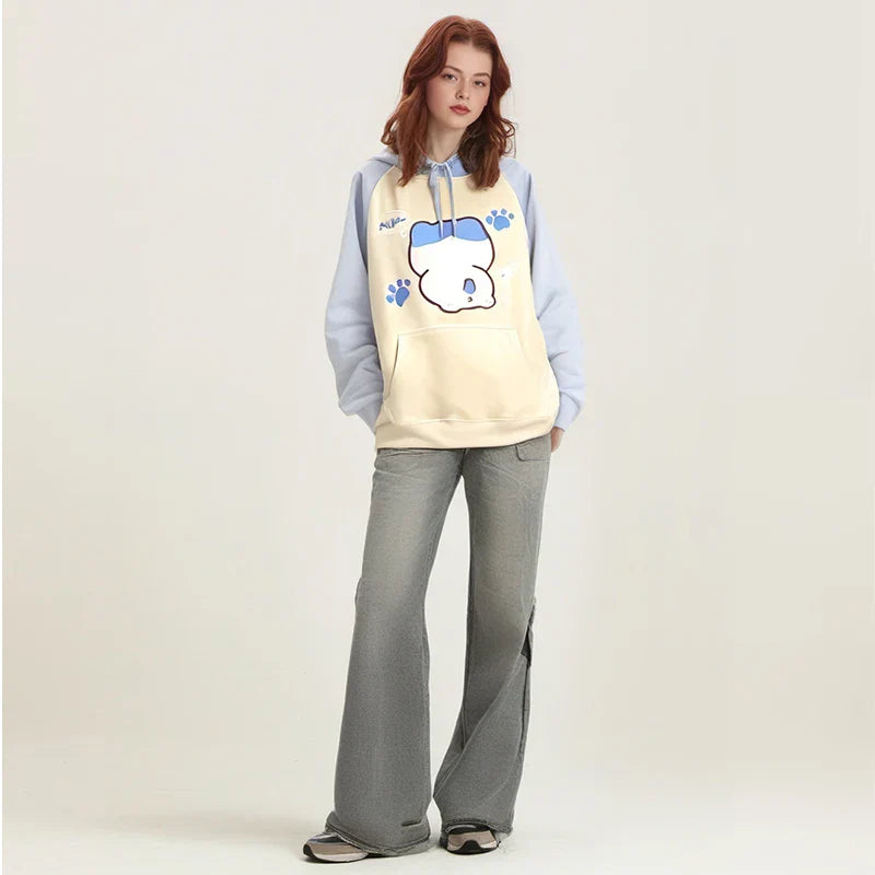 Woman wearing kuromi print kawaii sweatshirt with blue sleeves and paw prints paired with gray pants