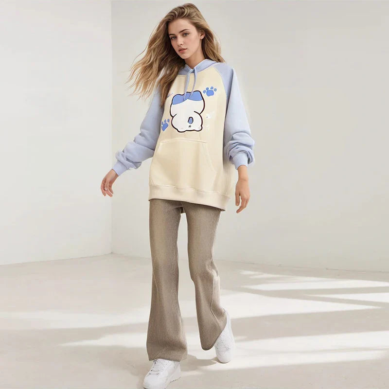 Woman wearing kuromi print kawaii sweatshirt with cream and light blue color blocking and paw print design